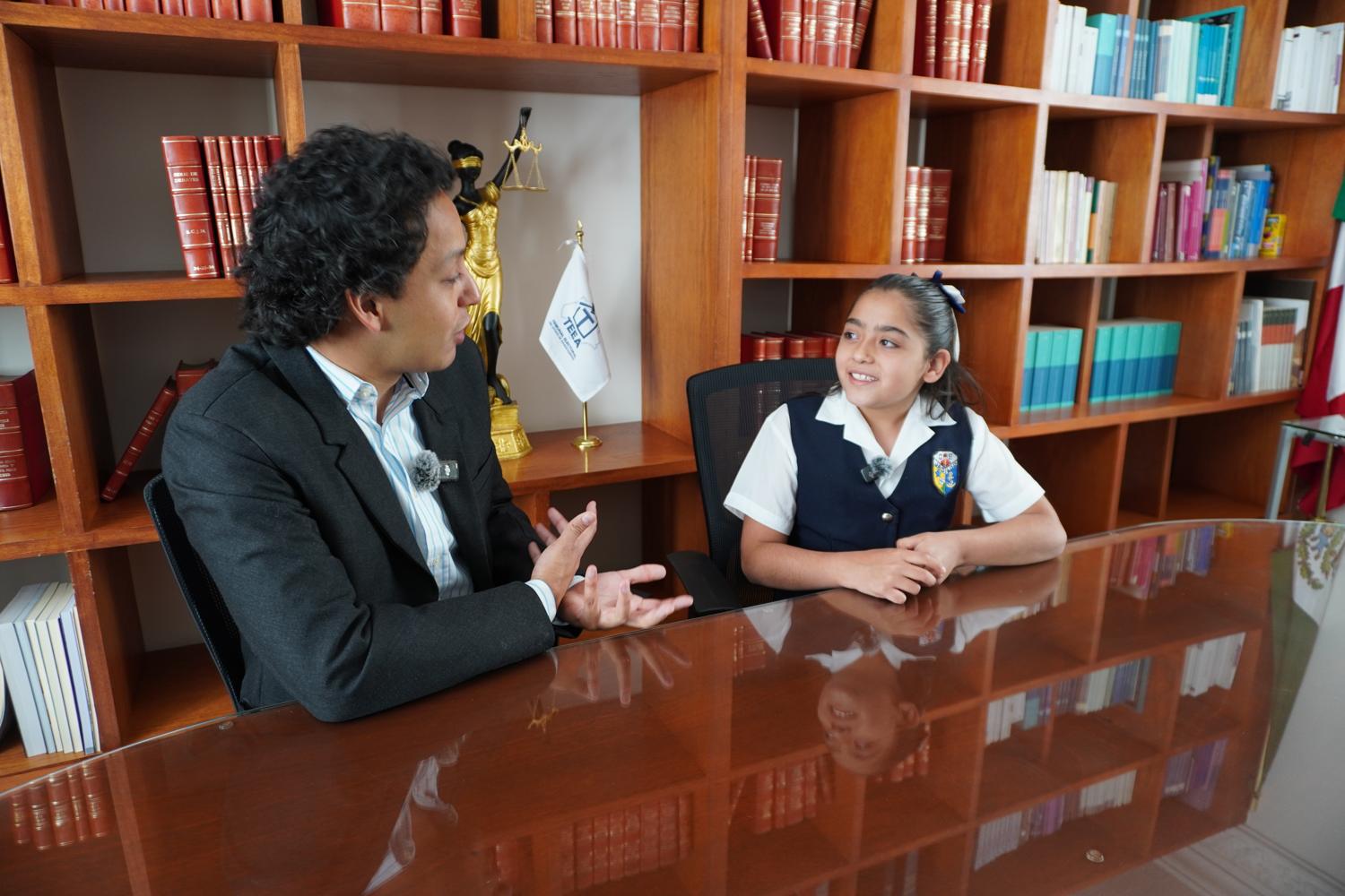 Una niña conversa con personal del Tribunal en una actividad de cultura cívica.
